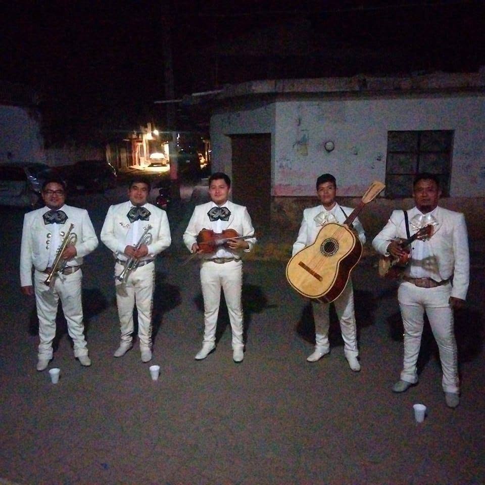 Mariachi tocando en una serenata íntima con gran emoción musical.