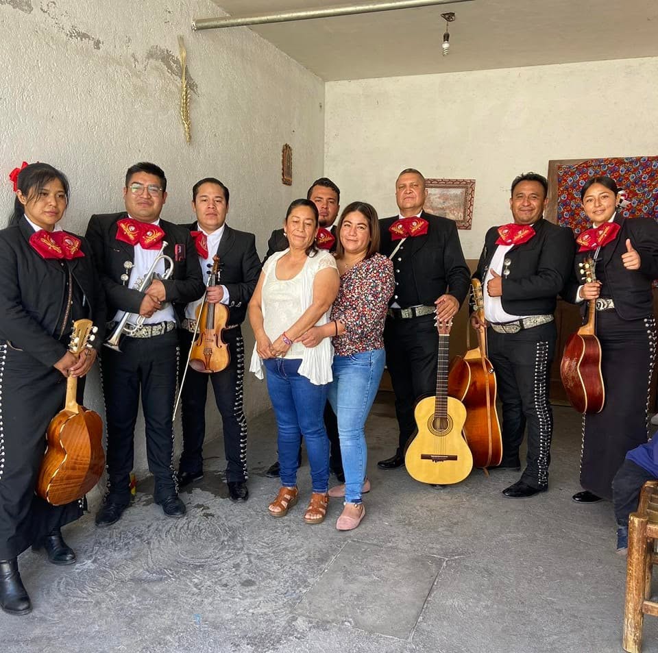 Músicos del Mariachi Juvenil Azteca junto a festejadas en su reunión familiar.