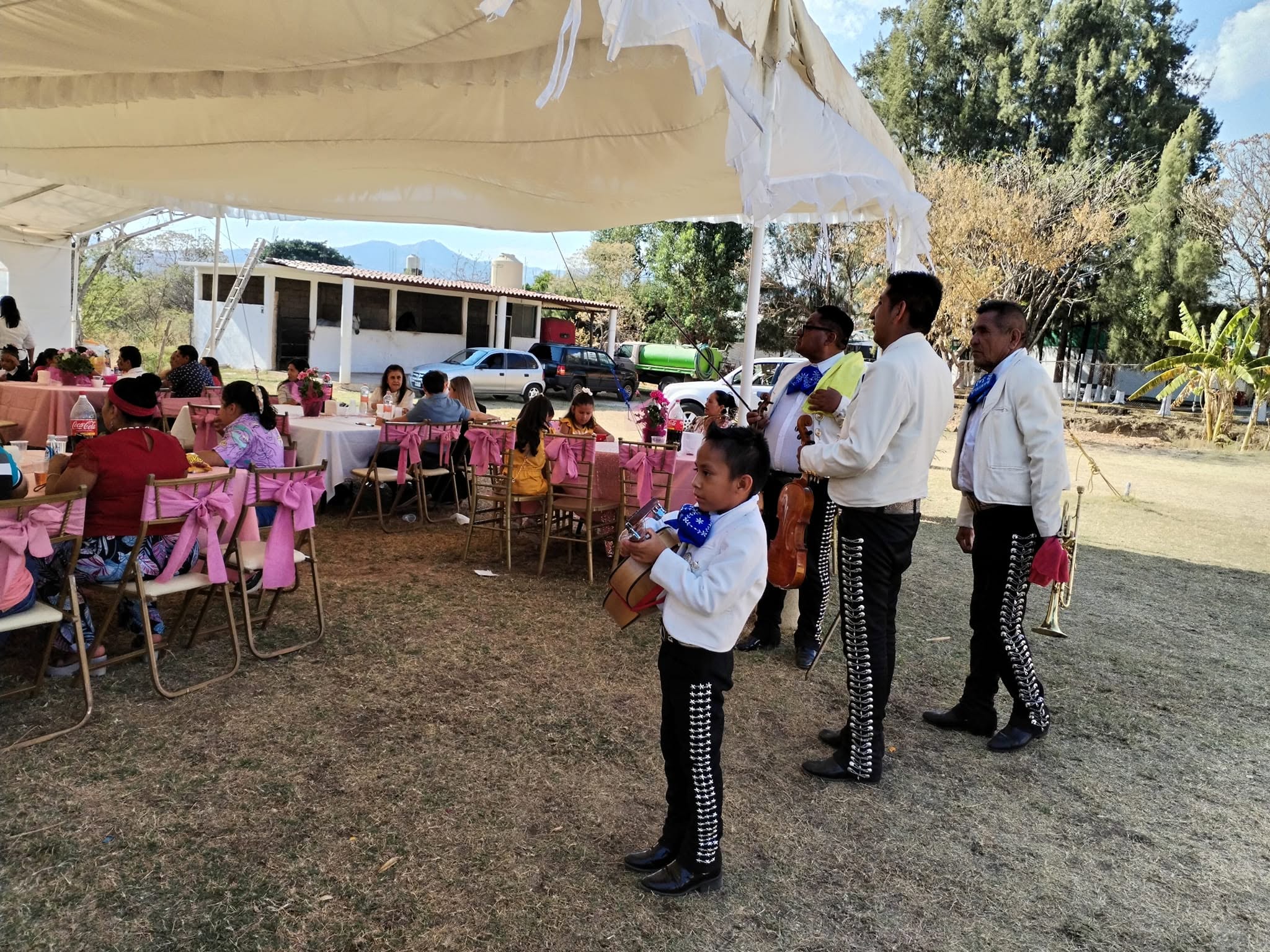 Mariachi Juvenil Azteca interpretando música en vivo en un evento al aire libre bajo carpas.